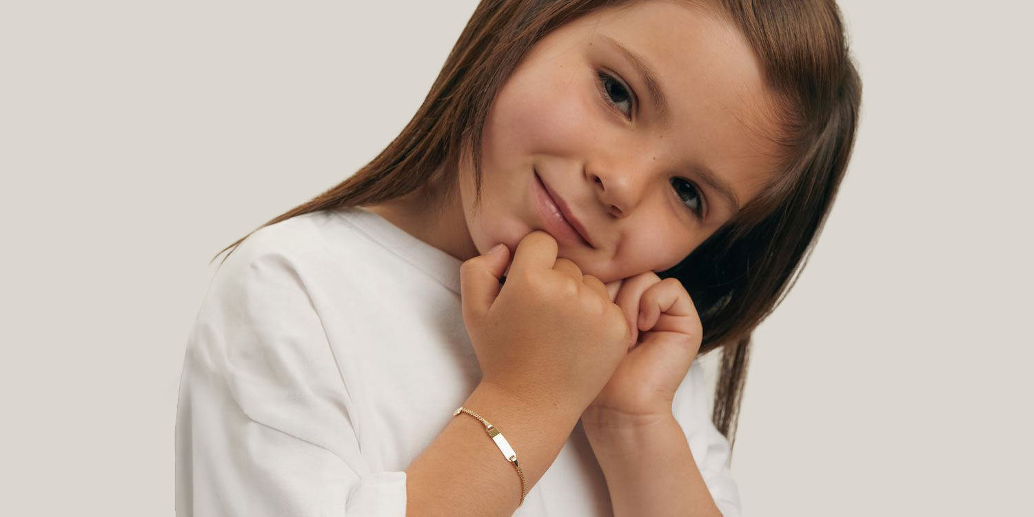 Junges Mädchen trägt Gravur-Armband aus Gold - Kinderarmschmuck für stilvolle Kids